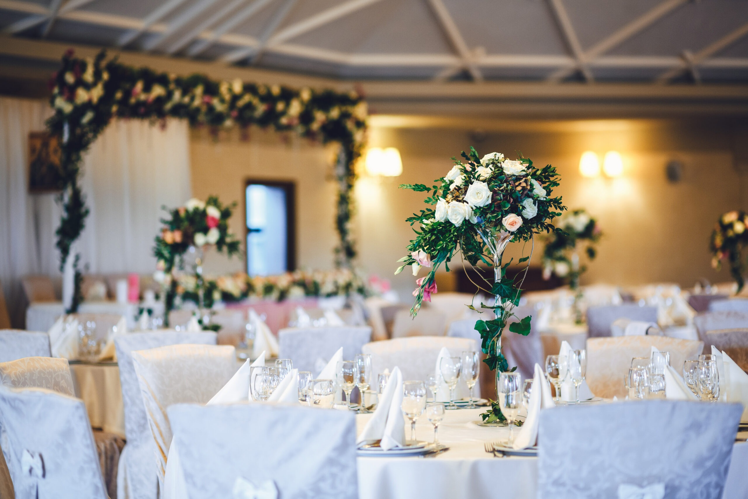 restaurant-hall-with-tables-decorated-with-tall-vases-with-roses-scaled